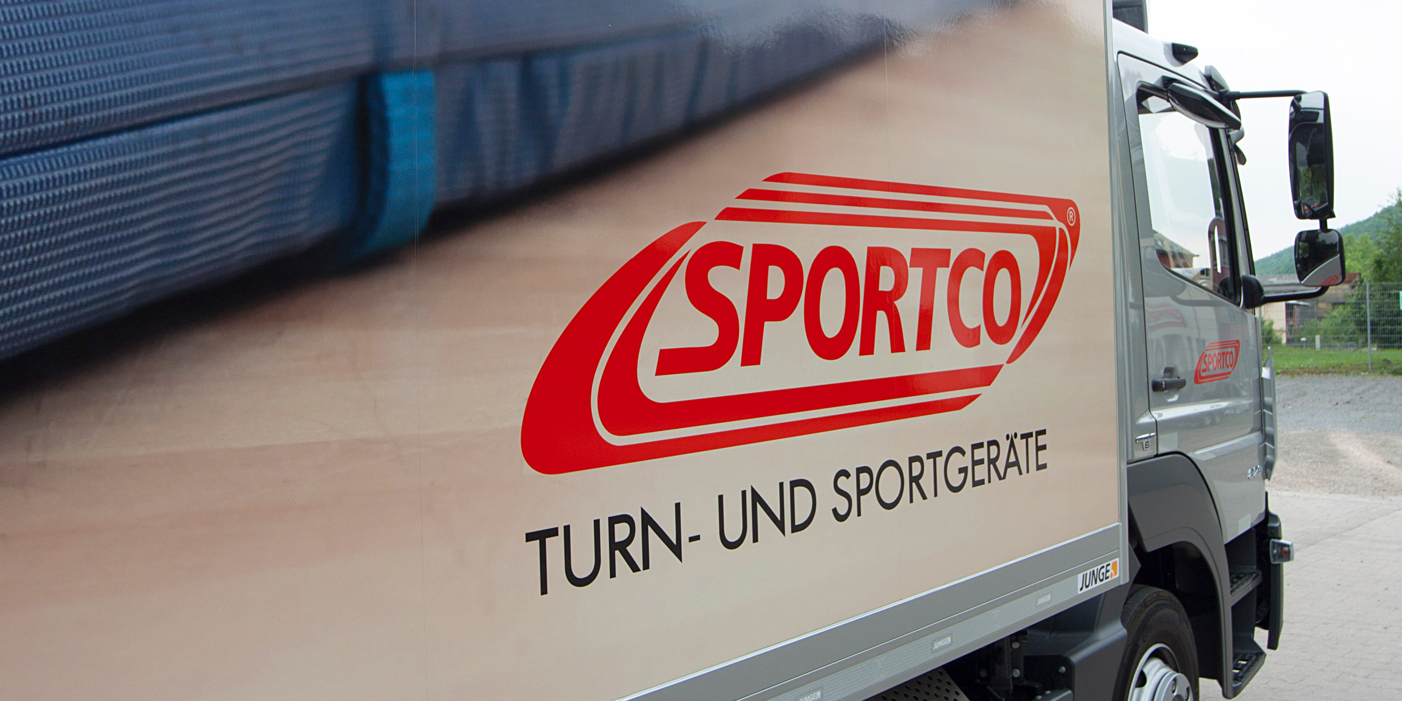 Seitenansicht vom Sportco-LKW mit großem roten Sportco-Logo mit dem Zusatz: Turn- und Sportgeräte.