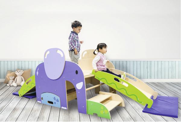 Kinder spielen auf einem bunten Indoor-Klettergerüst mit Rutsche und Treppe im Spielzimmer.