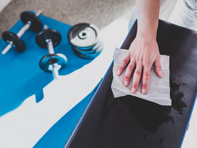 Therapeut reinigt mit einem Desinfektionstuch die Behandlungsliege.