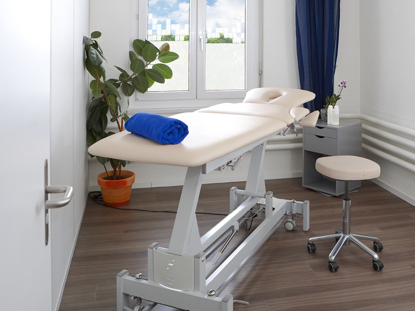 Behandlungsraum mit Behandlungsliege und Therapiehocker